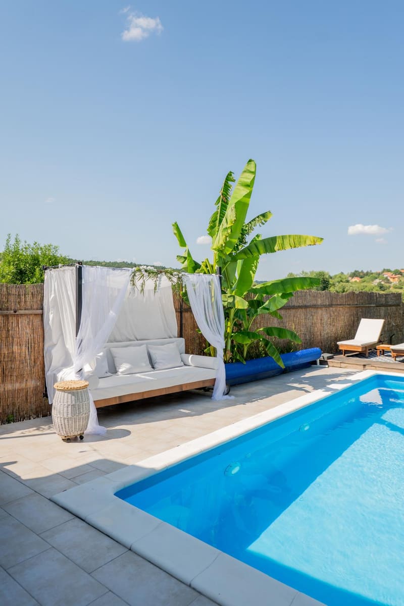Bazen i baldahin ležaljka u hladu banana u dvorištu Green Garden