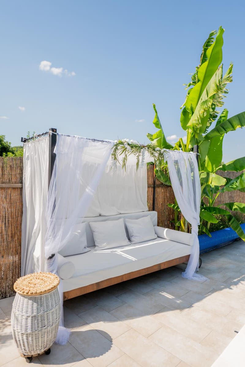Baldahin ležaljka sa belim zavesama pored bazena Green Garden